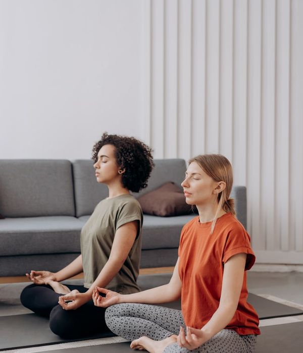 Woman in a calm yoga pose in a bright, minimalist room.